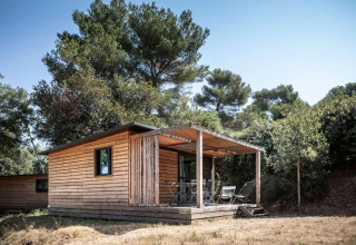 Houten chalet met terras in het bos bij Huttopia La Forêt de Janas in Provence-Alpes-Côte d’Azur, Frankrijk.