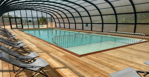 Piscina cubierta con tumbonas en Village Huttopia Pays de Condrieu, Auvernia-Ródano-Alpes, Francia.