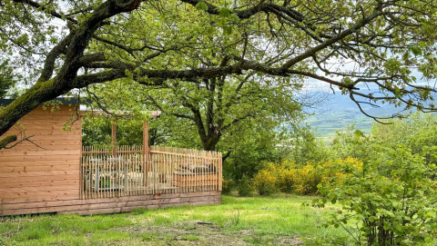 Cabaña de madera con terraza entre árboles en Huttopia Pays de Condrieu, Auvernia-Ródano-Alpes, Francia