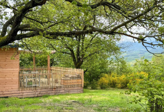 Holzhütte mit Terrasse und Ausblick im grünen Ferienpark Huttopia Pays de Condrieu, Auvergne-Rhône-Alpes