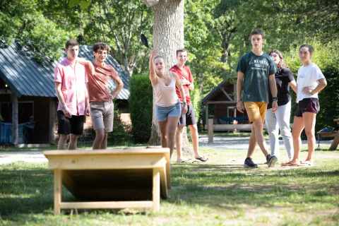 Teens play an outdoor game and enjoy sunny weather together at Village Huttopia Pays de Condrieu holiday park.
