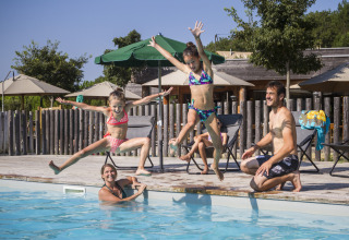 Familie nyder sommerferien ved at springe i poolen i Village Huttopia Pays de Condrieu, Auvergne-Rhône-Alpes.