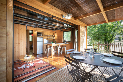Lyst træinteriør i Chalet Toronto på Village Huttopia Pays de Condrieu, med spise- og opholdsområde.