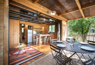 Lyst træinteriør i Chalet Toronto på Village Huttopia Pays de Condrieu, med spise- og opholdsområde.