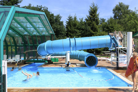 Außenpool mit blauer Wasserrutsche bei Veluwecamping De Pampel, einem Ferienpark in Gelderland, Niederlande.