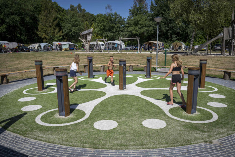 Niños juegan en un parque interactivo con columnas en Veluwecamping De Pampel, en Gelderland, Países Bajos.
