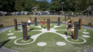 Niños juegan en un parque interactivo con columnas en Veluwecamping De Pampel, en Gelderland, Países Bajos.