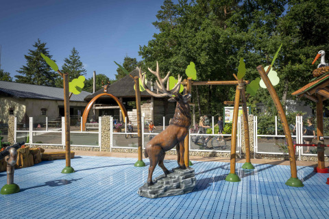 Spielplatz mit Hirschskulptur und Klettergerüsten im Veluwecamping De Pampel, Gelderland, Niederlande.