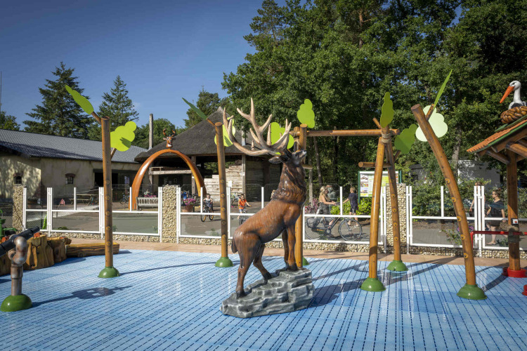Kindvriendelijke speeltuin met hertenbeeld en speeltoestellen bij Veluwecamping De Pampel in Gelderland.