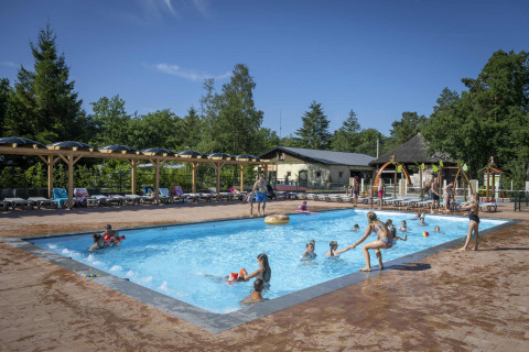 Bambini e famiglie si godono una giornata di sole in piscina al Veluwecamping De Pampel, Gelderland, Paesi Bassi.