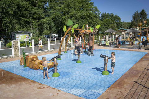 Bambini giocano nell’area giochi d’acqua al Veluwecamping De Pampel, Gelderland, Paesi Bassi sotto il sole.