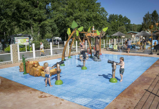 Bambini giocano nell’area giochi d’acqua al Veluwecamping De Pampel, Gelderland, Paesi Bassi sotto il sole.