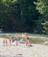 Des familles profitent de la rivière et du canoë au parc de vacances Huttopia Millau en Occitanie, France.