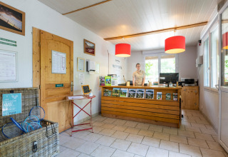 Receptionen på Huttopia Millau feriepark i Occitanie, Frankrig med personalet bag skranken.