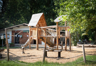 Parque infantil con estructura de madera en el parque vacacional Huttopia Millau en Occitania, Francia.