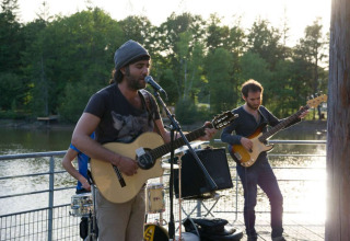 Muzikanten geven een live openluchtconcert aan het meer in Village Huttopia Senonches, Centre-Val de Loire, Frankrijk.