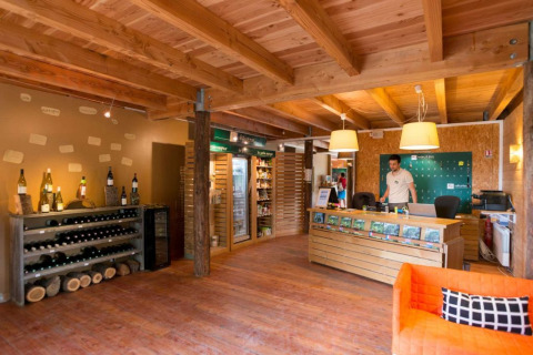 Recepción y tienda en Village Huttopia Senonches, parque de vacaciones en Centre-Val de Loire, Francia.