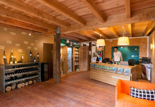 Recepción y tienda en Village Huttopia Senonches, parque de vacaciones en Centre-Val de Loire, Francia.