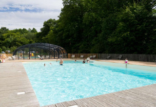 Udendørs swimmingpool med mennesker i ferieparken Village Huttopia Senonches, Centre-Val de Loire, Frankrig.