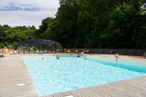 Outdoor swimming pool with people at Village Huttopia Senonches holiday park, Centre-Val de Loire, France.