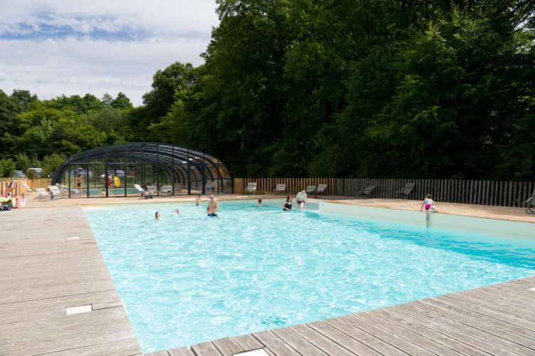 Outdoor swimming pool with people at Village Huttopia Senonches holiday park, Centre-Val de Loire, France.