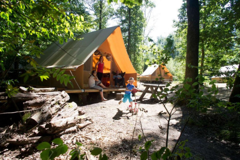 Familia disfruta de glamping en tiendas de campaña en Huttopia Senonches, Centro-Valle del Loira, Francia.