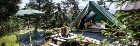 Tienda tipi Bonaventure en Village Huttopia Sud-Ardèche, Francia, rodeada de árboles y naturaleza exuberante.