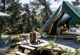 Tienda tipi Bonaventure en Village Huttopia Sud-Ardèche, Francia, rodeada de árboles y naturaleza exuberante.