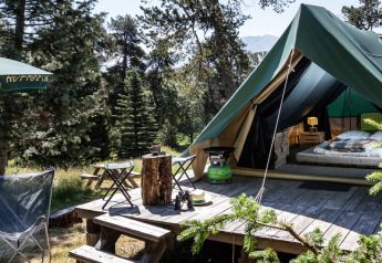 Tente tipi Bonaventure au Village Huttopia Sud-Ardèche en France, entourée de verdure et de forêt.