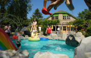 Niños juegan en una piscina infantil con estatuas coloridas en Veluwecamping 't Schinkel, Gelderland, Países Bajos.