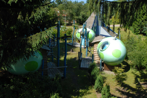 Spherical green cabins suspended in trees at Veluwecamping 't Schinkel holiday park, Gelderland, Netherlands.