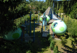 Spherical green cabins suspended in trees at Veluwecamping 't Schinkel holiday park, Gelderland, Netherlands.