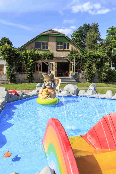 Outdoor children's pool with colorful statue and play area in front of a house at Veluwecamping 't Schinkel.