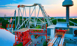 Pretpark met achtbaan en uitkijktoren bij zonsondergang dicht bij Castelnuovo del Garda, Veneto, Italië.