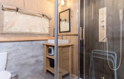 Baño de una tienda safari Stardust 40 Family Lodge con ducha, lavabo, madera y ventana en Bélgica.