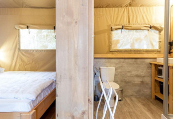 Stardust 40 Family Lodge safari tent interior with bedroom and bathroom, Petite Suisse, Belgium.