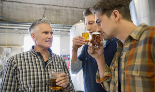 Tres hombres degustando cerveza juntos en una cervecería cerca de Hoenderloo, Güeldres, Países Bajos.