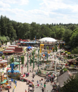 Parque de atracciones rodeado de bosque cerca de Hoenderloo, Gelderland, Países Bajos, con muchas atracciones y público.