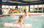 Un bambino gioca con una tavoletta in piscina coperta al Holiday Park Mölke, parco vacanza a Overijssel, Olanda.