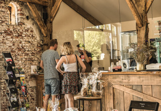Holiday Park Mölke: Guests at the reception in a rustic building with exposed beams and gift items in Overijssel.