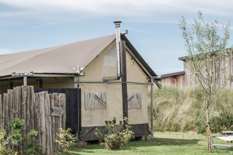 A tent lodge at Duynpark Het Zwanenwater holiday park in North Holland, Netherlands, with grassy surroundings.