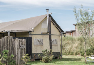 Ein Zelt auf Duynpark Het Zwanenwater, einem Ferienpark in Nordholland, Niederlande, mit Holzumzäunung.