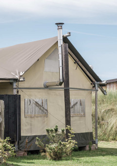 A tent lodge at Duynpark Het Zwanenwater holiday park in North Holland, Netherlands, with grassy surroundings.