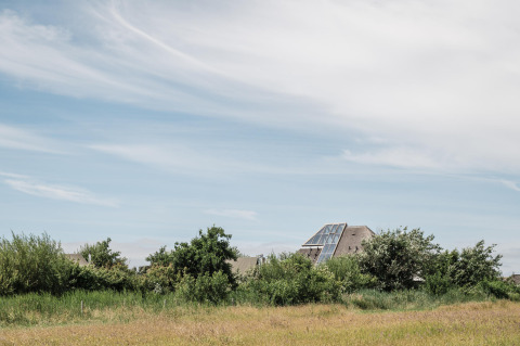 Maison moderne avec grandes fenêtres parmi les champs verdoyants de Duynpark Het Zwanenwater, Hollande-Nord.