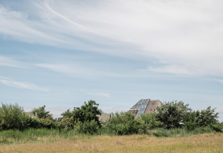 Maison moderne avec grandes fenêtres parmi les champs verdoyants de Duynpark Het Zwanenwater, Hollande-Nord.