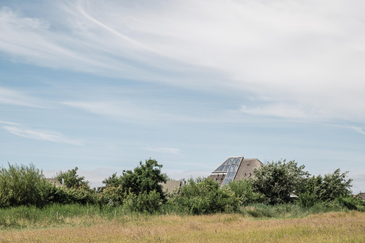 A modern house with large windows set among green fields at Duynpark Het Zwanenwater, North Holland.