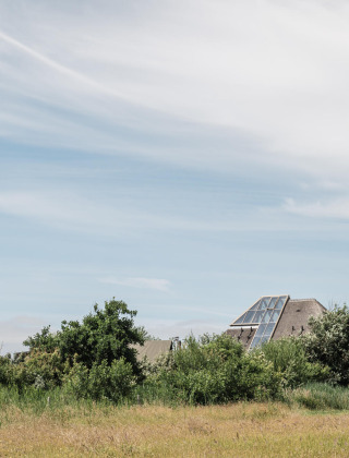 A modern house with large windows set among green fields at Duynpark Het Zwanenwater, North Holland.