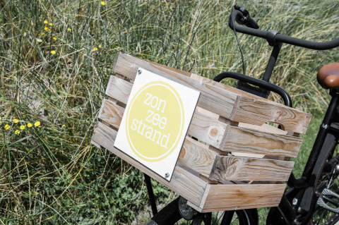 Bicicleta con caja de madera y cartel 'zon zee strand' en Duynpark Het Zwanenwater, Holanda Septentrional.
