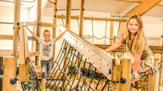 Dos niños juegan en una zona de juegos cubierta en Holiday Park Mölke, Overijssel, Países Bajos.