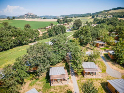 Vista aerea dei bungalow in legno nel verde di Huttopia Pays de Cordes sur Ciel, Occitania, Francia.